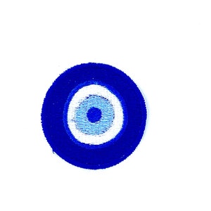Op de afbeelding: Een blauwe en witte amulet in de vorm van een boze oog, met een witte cirkel rond een blauwe cirkel. De amulet is een populair symbool voor bescherming tegen ongeluk.