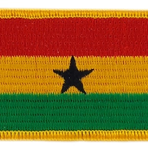 Puede incluir: Un parche rectangular bordado con la bandera de Ghana. La bandera tiene tres franjas horizontales de color rojo, amarillo y verde, con una estrella negra de cinco puntas en el centro de la franja amarilla.