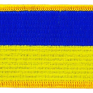 Könnte beinhalten: Ein blauer und gelber gestickter Aufnäher mit gelbem Rand. Der Aufnäher ist rechteckig und hat einen genähten Rand.
