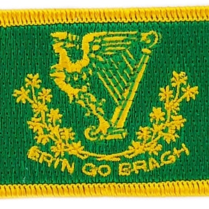 May include: A green embroidered patch with a gold border. The patch features a gold harp with a yellow inscription that reads "Erin Go Bragh".