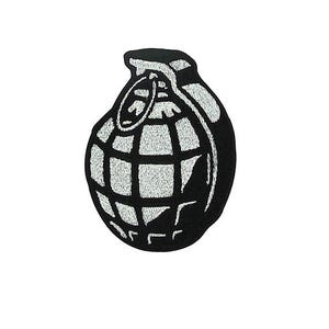 Puede incluir: Parche bordado en blanco y negro con forma de granada. El diseño de la granada presenta un patrón de cuadrícula y un anillo de tracción en la parte superior. El parche es para ropa o accesorios.