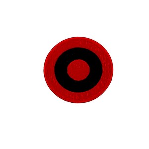 Può includere: Una toppa circolare con un anello esterno rosso, un anello centrale nero e un centro rosso. La toppa è posta su uno sfondo bianco.