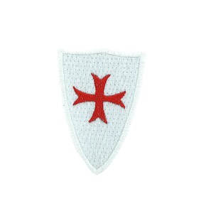 Puede incluir: Parche blanco bordado con forma de escudo con una cruz roja en el centro.