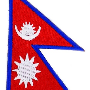Könnte beinhalten: Eine rote dreieckige Flagge mit einem blauen Rand. Die Flagge zeigt zwei weiße Symbole: eine stilisierte Sonne und eine Mondsichel mit einem Stern in der Mitte.