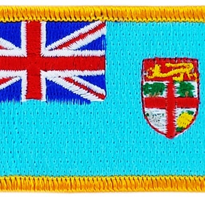 May include: A blue and red embroidered patch with a Union Jack on the left and a coat of arms on the right. The patch is surrounded by a yellow border.