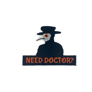 Może przedstawiać: Czarno-biała naszywka z haftem przedstawiająca lekarza od zarazy z długim nosem i kapeluszem. Naszywka zawiera napis "NEED DOCTOR?" w kolorze pomarańczowym.