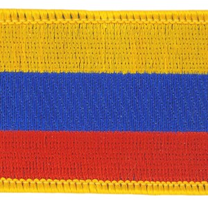 May include: A yellow, blue, and red embroidered patch with a yellow border. The patch is a representation of the Colombian flag.