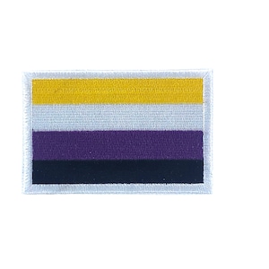 Op de afbeelding: Een witte geborduurde patch met een geel, wit, paars en zwart horizontaal gestreept ontwerp. De patch is een representatie van de non-binaire pride-vlag.