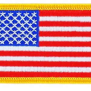 Könnte beinhalten: Ein kleiner gestickter amerikanischer Flaggen-Patch mit gelbem Rand. Die Flagge ist rot, weiß und blau.