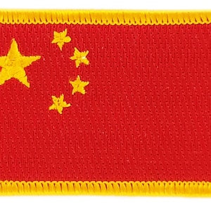 May include: A red embroidered patch with a yellow five-pointed star and four smaller stars in the top left corner. The patch is surrounded by a yellow border.
