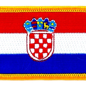 Könnte beinhalten: Ein gestickter Aufnäher mit dem kroatischen Wappen in den Farben Rot, Weiß und Blau. Der Aufnäher hat einen gelben Rand.