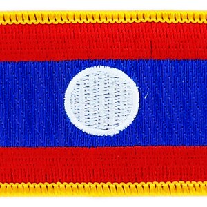 May include: A rectangular embroidered patch with a yellow border. The patch features the flag of Laos, with three horizontal red stripes, a blue stripe in the middle, and a white circle in the center of the blue stripe.