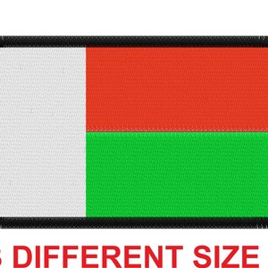 Puede incluir: Un parche rectangular con un diseño de rayas horizontales blancas, rojas y verdes. El parche tiene un borde negro con un borde deshilachado.