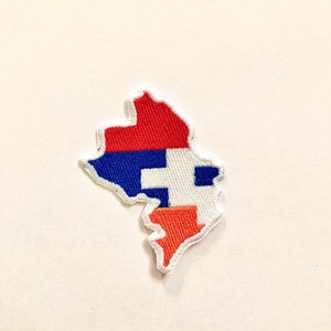 Puede incluir: Un parche bordado con forma del estado de Missouri, en los colores rojo, blanco y azul.