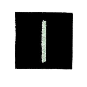 Pode incluir: Um patch quadrado preto com uma linha vertical bordada em verde claro no centro. O patch tem uma aparência texturizada e a linha está ligeiramente descentrada.