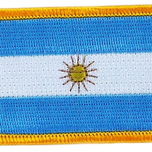May include: A blue and white embroidered patch with a yellow sun in the center. The patch has a yellow border.