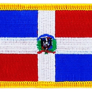 Puede incluir: Un parche bordado con la bandera de la República Dominicana. La bandera es una tricolor horizontal de azul, blanco y rojo, con una cruz blanca en el centro. La cruz está centrada en un pequeño escudo de armas que presenta una palmera verde y un escudo azul con una cruz blanca.