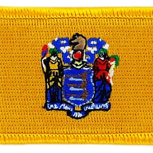 May include: A yellow embroidered patch featuring the state seal of New Jersey. The seal depicts a horse, a shield, and two figures.