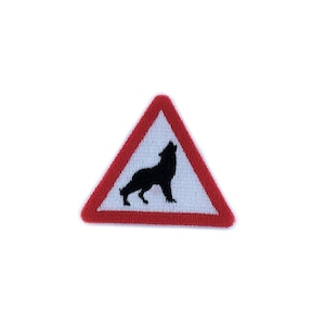 May include: A red and white triangular warning sign with a black silhouette of a wolf howling inside. The sign is a warning for the presence of wolves.
