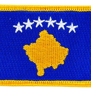 May include: A blue embroidered patch with a yellow outline. The patch features a yellow outline of the country of Kosovo and six white stars in a semi-circle above the outline.