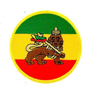 May include: Embroidered patch featuring a brown lion holding a staff, set against a background of green, yellow, and red. The lion is detailed with a crown and intricate design. The patch is circular with a yellow border.