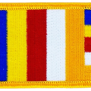 Könnte beinhalten: Ein rechteckiger gestickter Aufnäher mit einem buddhistischen Gebetsfahnen-Design. Die Flagge hat sechs vertikale Streifen in Blau, Gelb, Rot, Weiß, Gelb und Orange. Der orangefarbene Streifen hat ein kleineres weißes und rotes Rechteck auf der rechten Seite.
