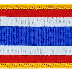 May include: A red, white, and blue embroidered patch with a yellow border. The patch features the flag of Thailand.