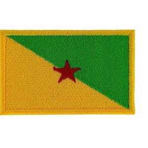 May include: Embroidered patch featuring the flag of French Guiana. The design includes a yellow and green background with a red star in the center. The patch has a yellow border.