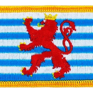 Peut inclure: Écusson brodé représentant le drapeau du Luxembourg. Il présente des rayures bleues et blanches, un lion rouge rampant et une bordure dorée. L'écusson est de forme rectangulaire.