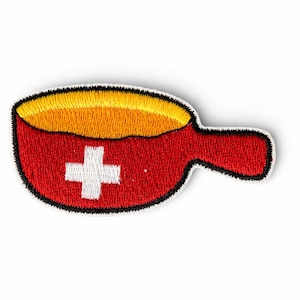 Peut inclure: Écusson brodé représentant une poêle rouge avec une croix blanche, remplie de jaune et d'orange. L'écusson a une bordure noire et une poignée. Ce patch est probablement un motif sur le thème suisse.