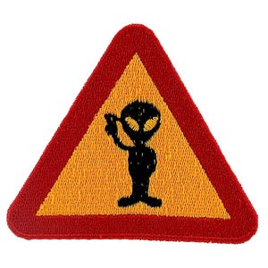 May include: Embroidered patch in a triangular shape with a red border and a yellow interior. The patch shows a black alien figure holding a ray gun. The alien is centered on the yellow background.