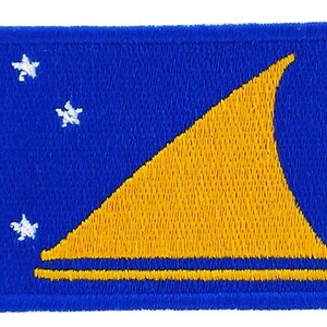 May include: Embroidered patch featuring the flag of Tuvalu. The patch has a blue background with a yellow triangle and four white stars. The flag is rectangular in shape.