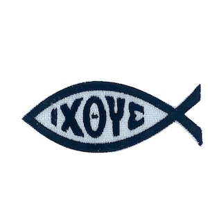 Può includere: Una toppa ricamata in bianco e nero a forma di pesce con la parola "IXOYE" all'interno.