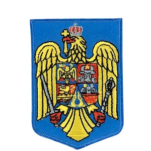 Può includere: Toppa ricamata con lo stemma rumeno. Il disegno presenta un'aquila dorata che tiene una spada e uno scettro, con uno scudo che mostra vari simboli. La toppa ha un bordo blu ed è posta su uno sfondo bianco.