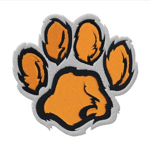 Peut inclure: Patch brodé en forme de patte d'animal, de couleur orange et noire. L'empreinte de la patte est soulignée de noir et a une texture duveteuse.