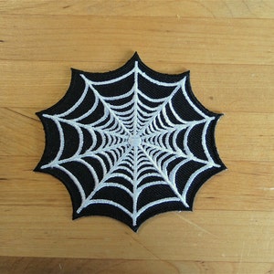 Puede incluir: Parche de telaraña en blanco y negro. El parche presenta un fondo negro con un diseño de telaraña blanca. Este artículo con temática de Halloween es ideal para ropa o accesorios.
