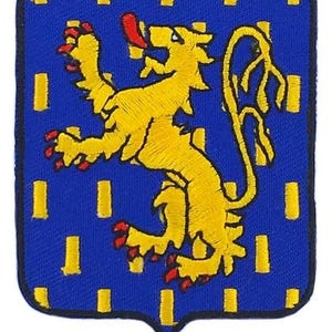 Op de afbeelding: Geborduurde patch met een gele klimmende leeuw op een blauwe achtergrond. De leeuw heeft rode accenten op zijn klauwen en tong. Het blauwe veld is versierd met gele rechthoeken. De patch heeft een schildvorm.
