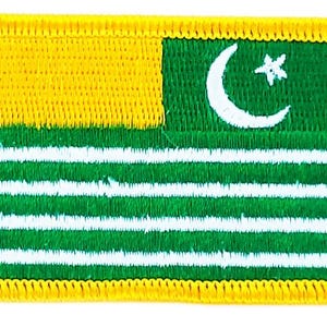 Könnte beinhalten: Gestickter Aufnäher mit der Flagge von Azad Kaschmir. Das Design umfasst einen gelben oberen linken Bereich, ein grünes Feld mit weißen Streifen sowie einen weißen Halbmond und Stern. Der Aufnäher hat einen gelben Rand.