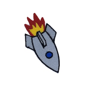 May include: A grey rocket with a blue window and red and yellow flames coming out of the back.