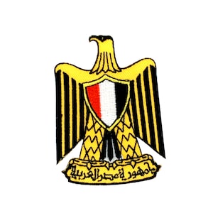 Op de afbeelding: Een geborduurde patch met het nationale embleem van Egypte. De patch toont een gouden adelaar met uitgespreide vleugels, die een schild vasthoudt met de kleuren van de Egyptische vlag. De adelaar zit op een banner met Arabische tekst.