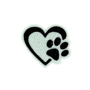 Puede incluir: Un parche bordado con una huella de pata negra dentro de un corazón delineado en negro. El corazón y la huella de la pata están sobre un fondo blanco. El parche es probablemente para los amantes de las mascotas.