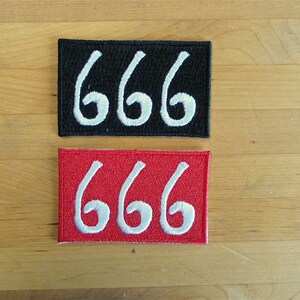 Puede incluir: Dos parches bordados con el número 666 en blanco sobre fondo negro y rojo.