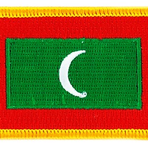 May include: A red, green, and white embroidered patch with a crescent moon design. The patch has a yellow border.