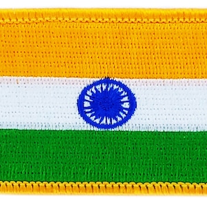 Può includere: Una toppa ricamata della bandiera indiana. La bandiera è rettangolare e presenta tre strisce orizzontali: zafferano in alto, bianco al centro e verde in basso. La striscia bianca ha una ruota blu al centro.