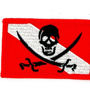 Könnte beinhalten: Gestickter Aufnäher mit einem Totenkopf und gekreuzten Schwertern auf rotem Grund. Das Design umfasst einen weißen diagonalen Streifen und einen roten Rand. Der Totenkopf und die Schwerter sind schwarz.