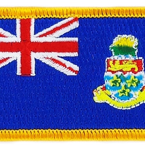 Puede incluir: Un parche bordado con la bandera de las Islas Caimán. La bandera es azul con una Union Jack en la esquina superior izquierda y el escudo de armas de las Islas Caimán en la esquina inferior derecha.