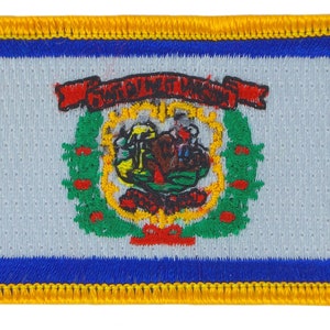 Könnte beinhalten: Ein weißer Patch mit einem blauen Rand und einem gelben Rand außen herum. Der Patch zeigt das Staatssiegel von West Virginia, das einen Kranz aus grünen Blättern, ein rotes Band mit den Worten "MONTANI SEMPER LIBERI" in Schwarz und ein braunes und gelbes Bild eines Bauern mit einem Gewehr und einer Garbe Weizen enthält.