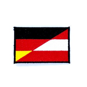 May include: A black, red, and yellow embroidered patch with a diagonal white stripe. The patch is a combination of the German and Austrian flags.