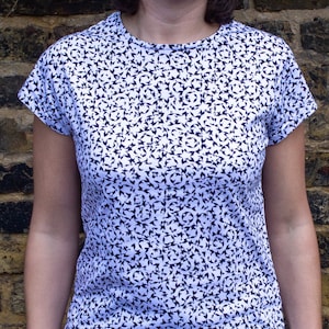 May include: A white t-shirt with a black and white geometric pattern.