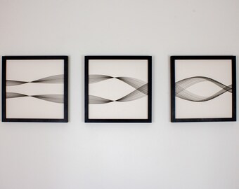 May include: Three black framed prints with abstract line art in shades of gray on a white background.